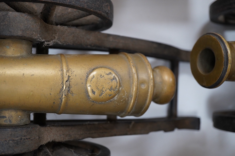 A pair of brass and cast iron model cannons, 34cm in length